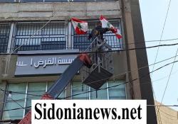 بالفيديو والصور  :إقفال فرع القرض الحسن في صيدا وفرق بلدية صيدا أزالت لافتة الجمعية من واجهة المبنى ورفعت الأعلام اللبنانية مكانها